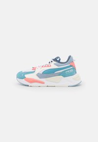 Chaussure de course Puma RS blanche, bleue et corail avec des empiècements en suède et en mesh, lacets blancs et semelle épaisse et rembourrée, montrée de côté sur un fond blanc.