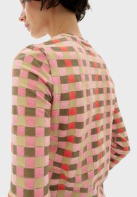 Langærmet skjorte med et multifarvet ternet mønster i pink, rød, grøn og beige. Blødt stof med en rund halsudskæring.