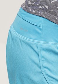 Pantalones cortos deportivos Dri-FIT azules con tejido texturizado, una cinturilla suave y un logotipo sutil. El diseño enfatiza la comodidad ligera.