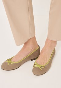 Gray suede ballet flats with a rounded toe, accented by a light green edge and bow detail. Low, slightly raised heel design.