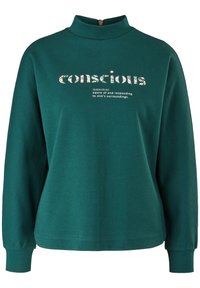 Teal Baumwoll-Sweatshirt mit hohem Kragen, langen Ärmeln und Reißverschluss. Mit floral gemustertem Text, der "bewusst" und dessen Definition zeigt.