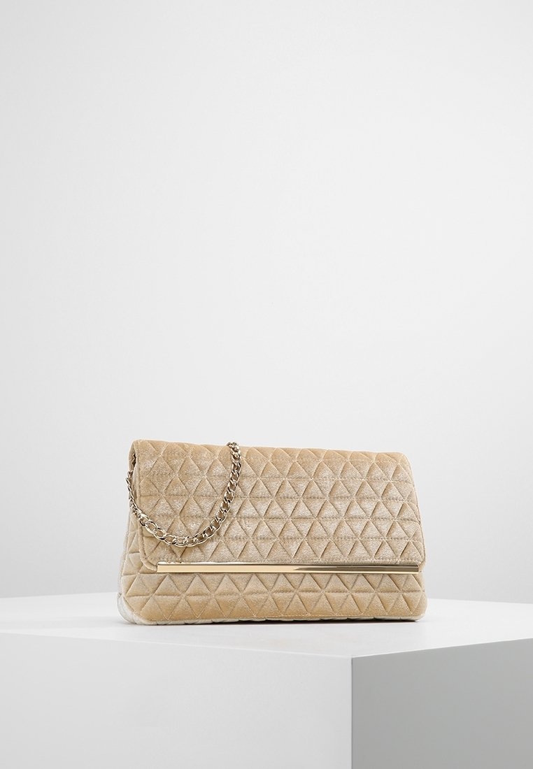 Beżowa pikowana aksamitna torebka na ramię z łańcuszkiem, wyposażona w klapkę zamykającą i teksturowany wzór diamentowy na powierzchni.