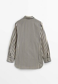 Chemise à manches longues rayée verticalement noir et blanc avec des poignets boutonnés, vue de dos sur fond blanc.