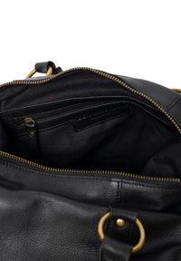 Zwarte leren handtas met een ritsafsluiting. Interieur met een donkere stofvoering, een ritsvak en een insteekvak voor kaarten. Gouden hardwareaccenten.