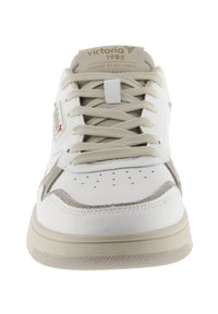 Sneaker bianco con tomaia in pelle liscia e accenti in suede grigio chiaro. Presenta una punta forata, lacci beige e suola in gomma testurizzata.