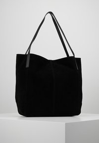 Czarna torebka zamszowa z dwoma długimi, płaskimi uchwytami. Charakteryzuje się widocznym szwem oraz usztywnionym, otwartym projektem.