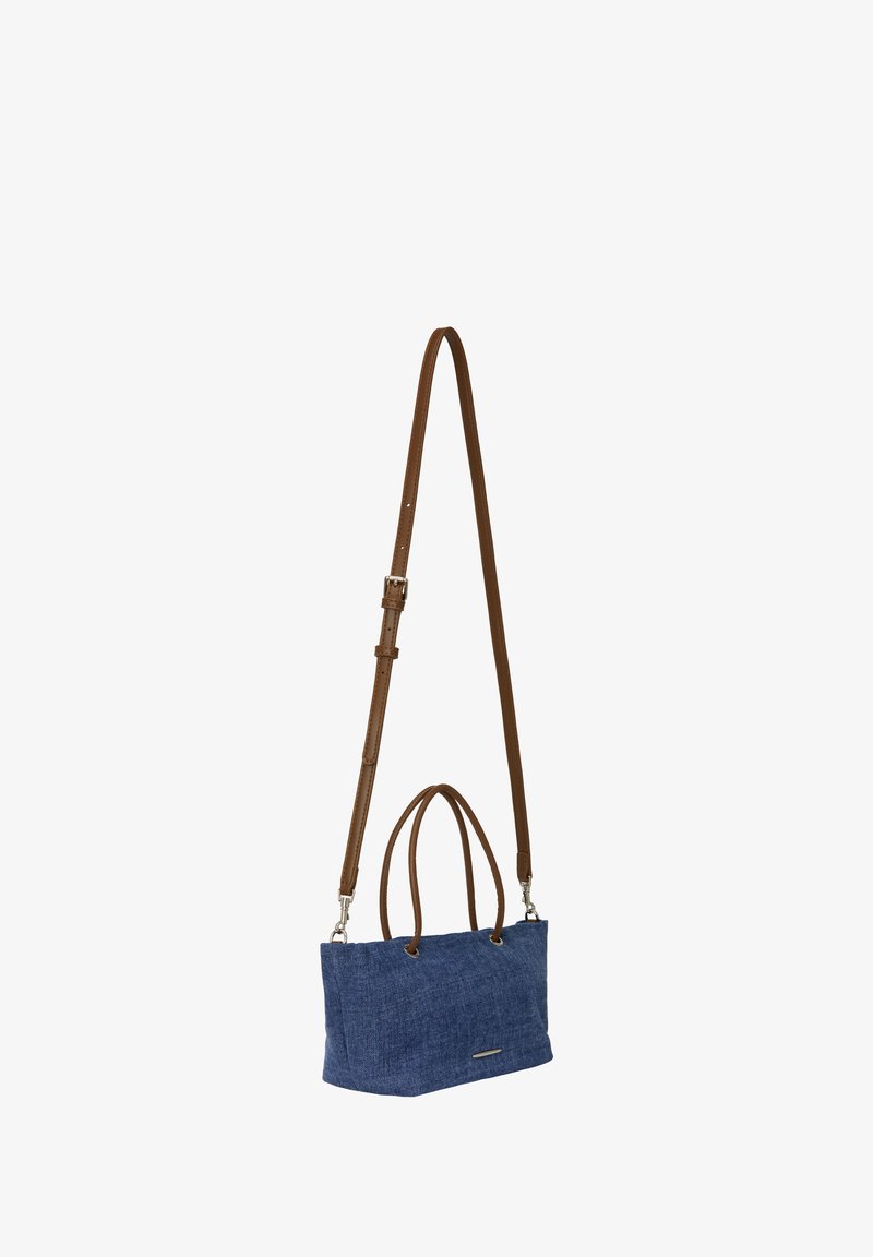 Denim totebag med to brune læderhåndtag og en justerbar rem. Firkantet form, tekstureret overflade, sølvfarvede hardware-detaljer.