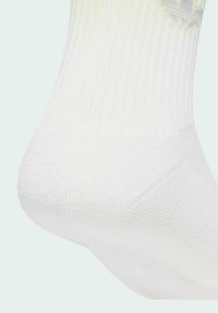 Biela ponožka s rebrovanou textúrou, obsahujúca jemný detail loga a zosilnenú pätu. Mäkká a flexibilná látka, navrhnutá pre pohodlie.