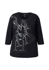 Schwarzes Langarm-T-Shirt mit rundem Halsausschnitt, das ein silbernes Grafikdesign mit überlappenden Buchstaben und Akzentnähten aufweist.