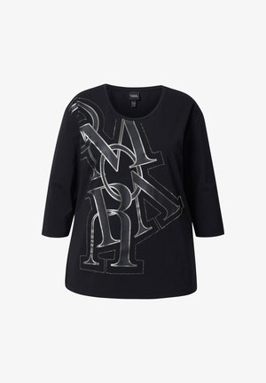 Musta pitkähihaisen T-paita, jossa on pyöreä kaula-aukko ja hopeinen graafinen kuvio, jossa on toisiinsa limittäin menevää tekstiä ja korostusompeleita.