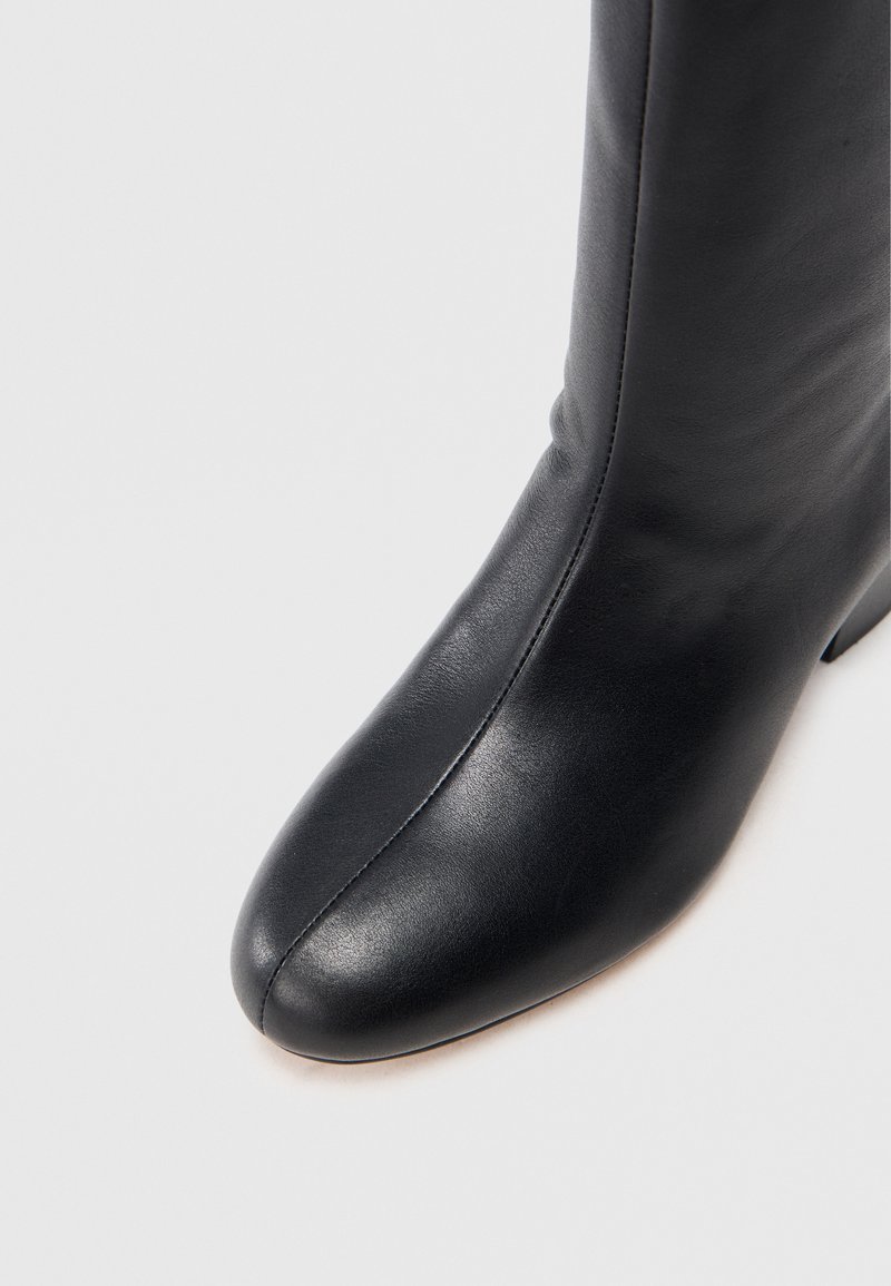 Schwarze Leder Stiefelette mit einer spitzen Zehe, glatter Oberfläche und einem schmalen Absatz. Verfügt über ein nahtloses Design und minimalistische Nähte.