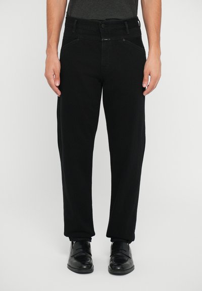 Black denim trousers with a straight fit, featuring a mid-rise waistband, front pockets, and subtle stitching details. Worn with black shoes.