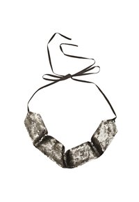 Zwarte stoffen ketting met een stropdas, voorzien van metallic zilveren pailletten die in een golfpatroon zijn gerangschikt. Het ontwerp bevat verstelbare lintsluitingen.