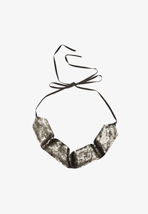 Collier en tissu noir avec des sequins métalliques argentés disposés en motif ondulé. Le design comprend des fermetures en ruban ajustables.