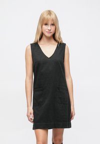 Čierne rifľové šaty bez rukávov s výstrihom do V, dvoma prednými vreckami a voľným strihom. Materiál je mierne štruktúrovaný a šaty sú dĺžkou po kolená.