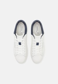 Sneakers bianchi in pelle con accenti blu navy, dotati di punta rotonda, design con lacci e logo sulla linguetta. Texture liscia con dettagli minimi.