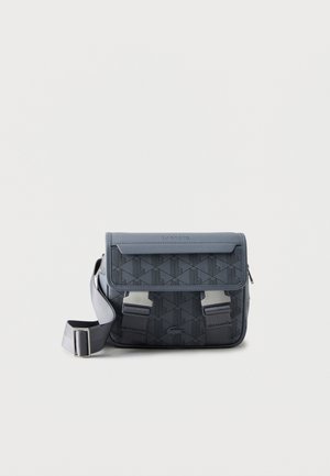 Borsa a tracolla grigio scuro con motivo geometrico, due fibbie argentate frontali, tracolla regolabile e logo Lacoste sulla patta.