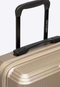 Hard-shell beige koffer met zwarte telescoop handgreep en bovenhandvat, voorzien van de merknaam "Wittchen" op het handvat.
