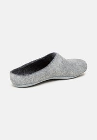 Chausson en feutre gris avec une forme arrondie, texture douce et intérieur noir. Présente un dos fermé et des accents minimalistes.