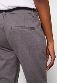 Grå skräddarsydda byxor med en bakficka och subtil textur, med rak passform och slät midja.