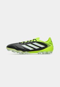 Black and neon yellow Adidas Copa soccer cleat with white stripes, black laces, and studded sole for turf play.