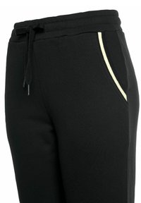 Schwarze Jogginghose aus weichem Stoff; verfügt über einen elastischen Bund mit Kordelzug und einen kontrastierenden hellen Streifen entlang der Taschen.