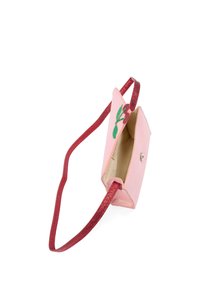 Różowa torebka materiałowa z błyszczącym czerwonym paskiem, zdobiona haftowanymi wisienkami i zatrzaskiem; o trójkątnym kształcie i miękkiej fakturze.