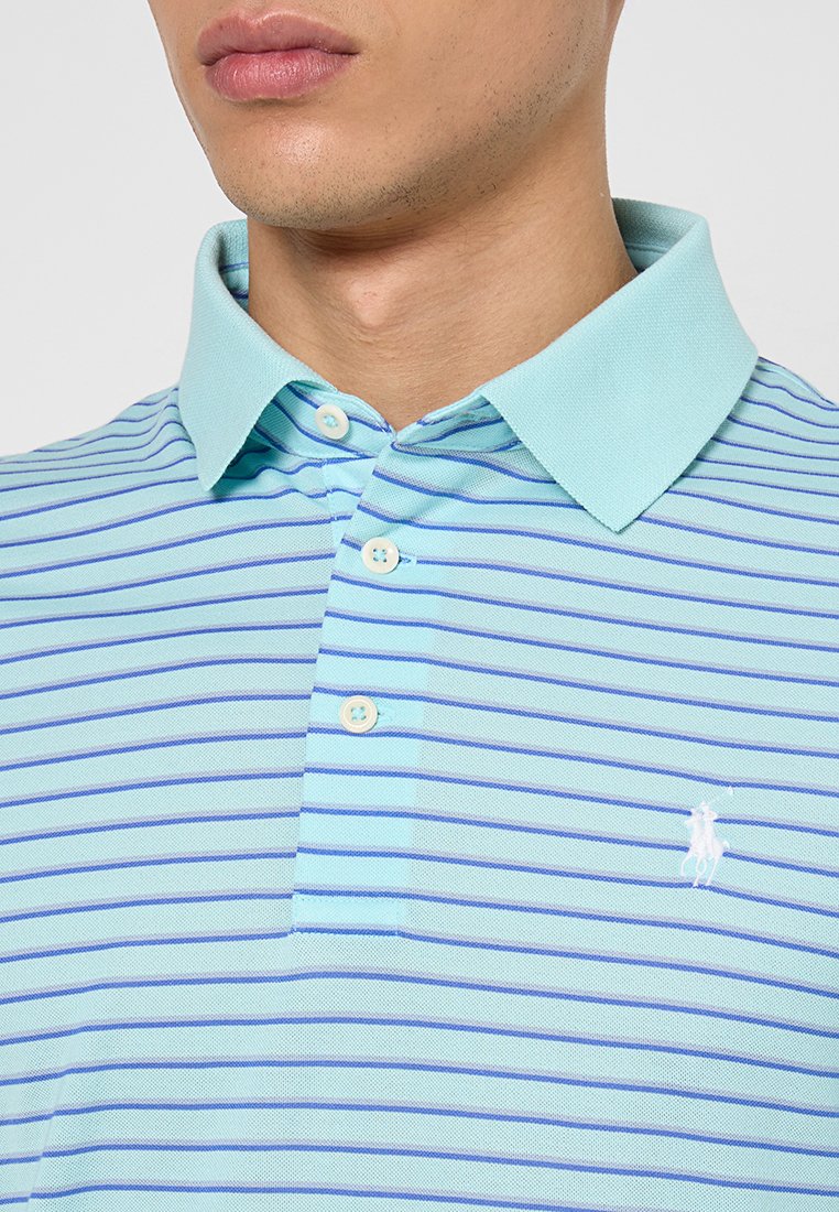 Polo de rayas azul claro hecho de un tejido texturizado. Presenta un collar clásico, una tapeta de tres botones y un logo bordado en el pecho.