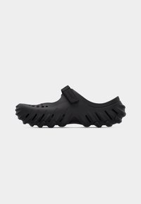 Sabot Crocs noir avec trous de ventilation, semelle robuste et bride réglable sur le dessus, présenté en profil latéral sur fond blanc.