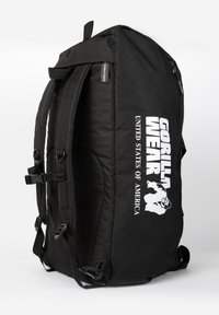 Black backpack with adjustable straps, prominent white "GORILLA WEAR" logo, and "UNITED STATES OF AMERICA" text, featuring durable fabric and zippers.