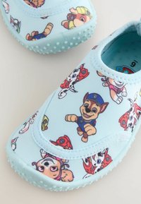 Baskets légères bleu clair pour enfants, ornées de motifs des personnages de PAW Patrol et dotées de semelles en caoutchouc texturé pour une meilleure adhérence.