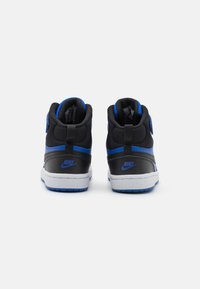 Felső részes sneaker fekete szintetikus anyagból, kék díszítésekkel, párnázott bokarésszel és fehér talppal, a saroknál látható logóval.