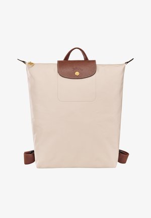 Beiger Rucksack aus Nylon mit einem braunen Lederdeckel, ausgestattet mit einem goldenen Druckknopf und verstellbaren braunen Trägern. Glatte Textur und minimalistisches Design.