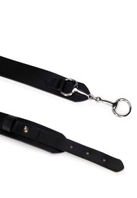 Correa de cuero negro con textura suave, hardware metálico circular y múltiples agujeros de ajuste para personalización de tamaño.
