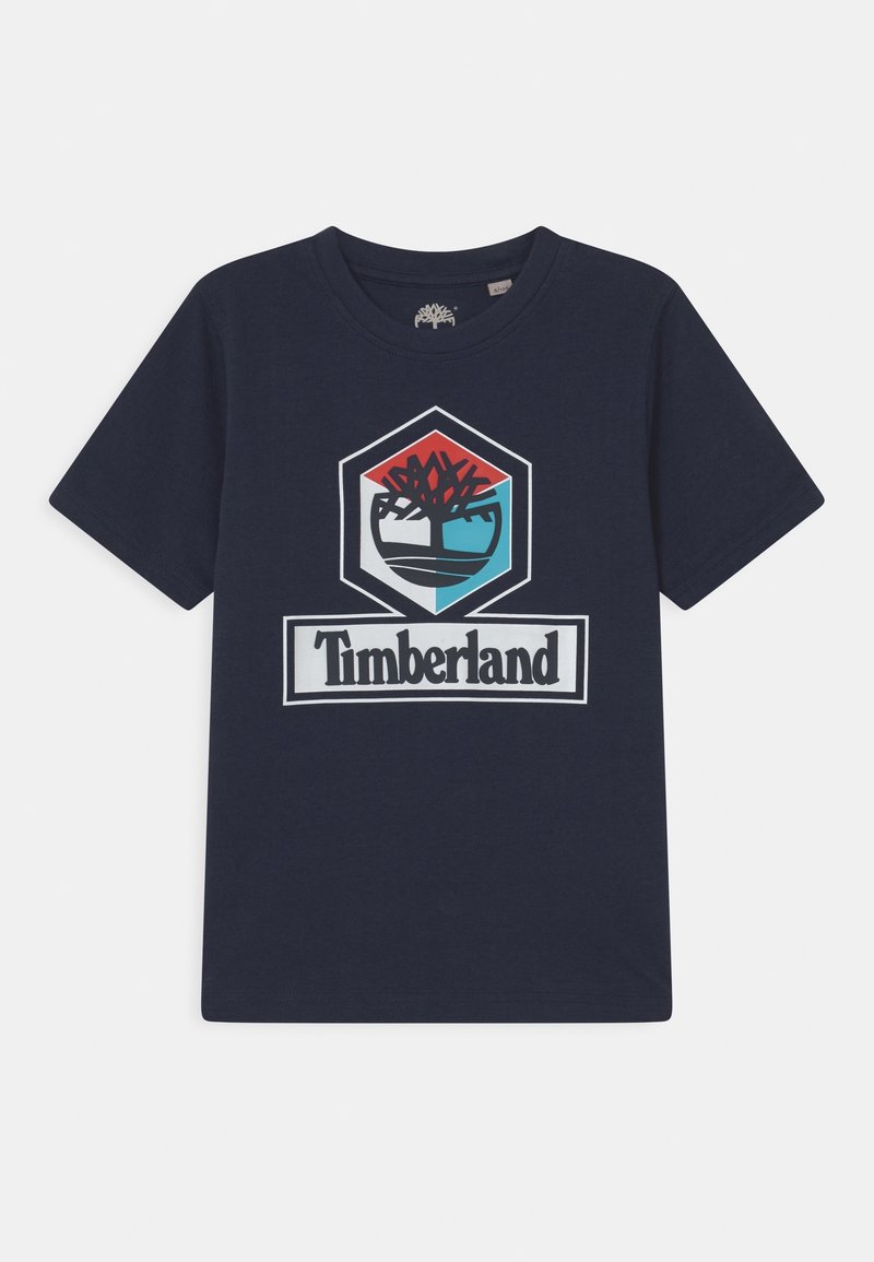 Mörkblå bomullströja med en stor hexagonal Timberland-logotyp i röd, svart, turkos och vit i mitten. Korta ärmar och rundad hals.