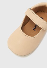 Μπεζ δερμάτινο παπούτσι Mary Jane με στρογγυλεμένη μύτη, φαρδιά λουράκι με αγκράφα και μαλακή εσωτερική επένδυση. Μαλακή σόλα με διακριτή υφή.