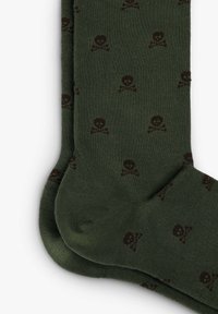 Grønne sokker lavet af en bomuldsblanding med et lille brunt skull og tværsbones mønster. Har ribbede manchetter og en sømløs tå-design.