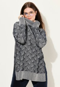 Maglione lavorato a maglia in navy e bianco con un motivo a onda, colletto alto e polsini a coste. Texture morbida, vestibilità comoda e fessure laterali all'orlo.