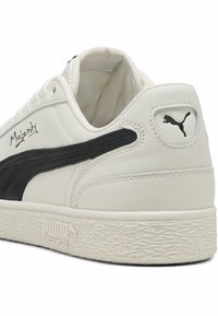 Hvide lædersneakers med et sort swoosh-design, struktureret gummisål og logo på hælen. Har signaturdetaljen "Majesty".