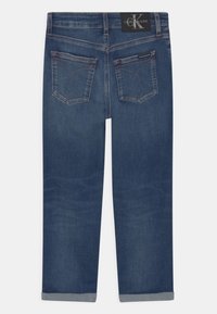 Jeans de color azul oscuro, fabricados en denim, con un diseño de pierna recta que presenta dos bolsillos traseros con costuras decorativas y un dobladillo con puño.