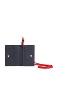Συμπαγές πορτοφόλι σε σκούρο μπλε δέρμα με κόκκινη επένδυση. Διαθέτει δύο διαμερίσματα, κλείσιμο με κουμπιά και αφαιρούμενο κόκκινο λουράκι για να το κρατάτε.