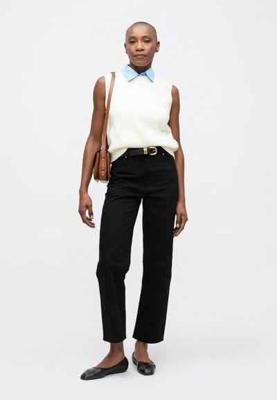 Suéter sin mangas blanco texturizado, camisa de cuello azul claro, pantalones negros de pierna recta, bailarinas negras, bolso cruzado marrón, textura suave.