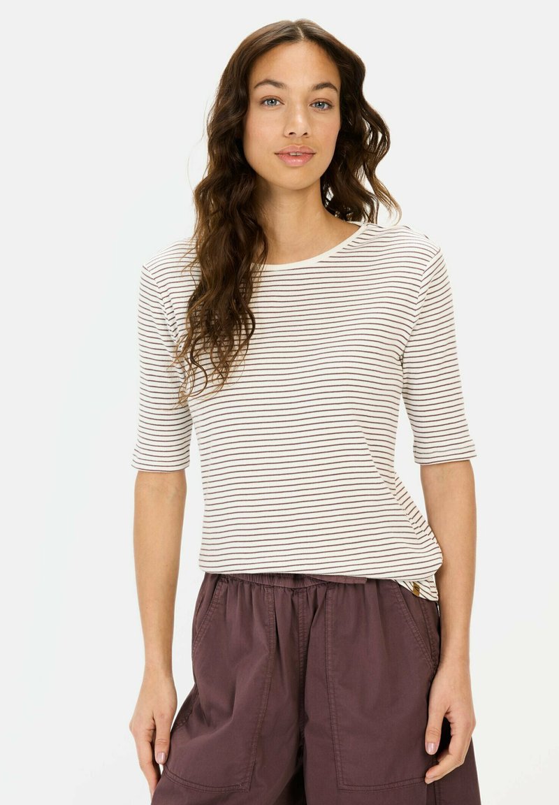 Gestreepte, lichtcrème en bruine top met driekwart mouwen en een ronde halslijn, gecombineerd met losse, donkerpaarse broek. Zachte textuur.