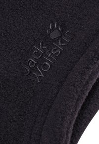 Tessuto in pile nero con superficie texture e il logo in rilievo sottile di "Jack Wolfskin" con dettaglio della zampa.