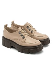 Beżowe skórzane buty o teksturowanym wykończeniu, okrągłym nosku i grubych brązowych gumowych podeszwach. Posiadają srebrne oczka i beżowe sznurówki.