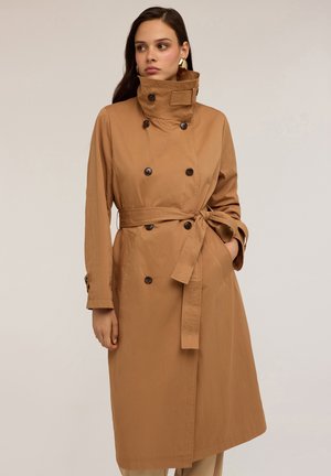 Trench coat marrone con colletto alto, chiusura doppiopetto, vita legata e maniche lunghe con dettagli a bottoni. Tessuto liscio e leggero.
