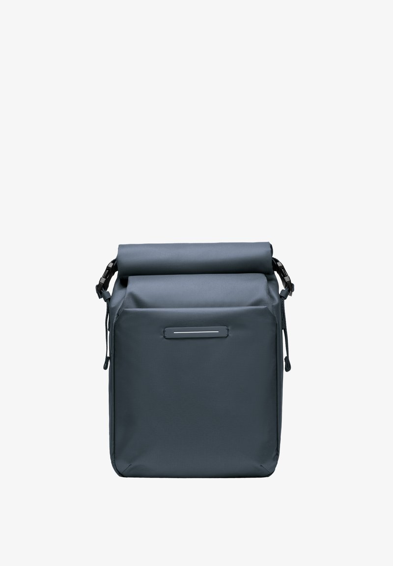 Sac à dos à rabat fabriqué en matériau gris résistant à l'eau ; il dispose de sangles ajustables, d'une texture subtile et d'une poche avant à glissière.