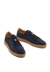 Granatowe zamszowe trampki z brązowymi gumowymi podeszwami, z ciemnoniebieskimi sznurówkami, teksturowanym panelem bocznym oraz małym pomarańczowym akcentem na języku.