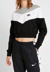 Nike kortärmad sweatshirt med en färgblockdesign i grått, vitt och svart. Mjukt tyg med rund hals och broderad logga.