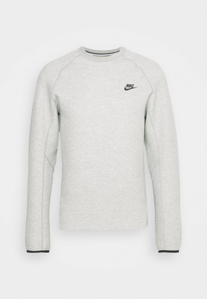 Sweat-shirt long à manches raglan en gris clair, col rond, avec un logo Nike noir sur le haut à gauche de la poitrine. Tissu texturé avec un bord contrastant.